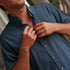 The Busted Prop blue button down shirt being adjusted by a man