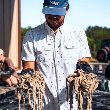man holding materials wearing oyster shirt