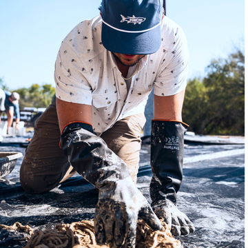 man with gloves working wearing the carlos bay oyster shirt