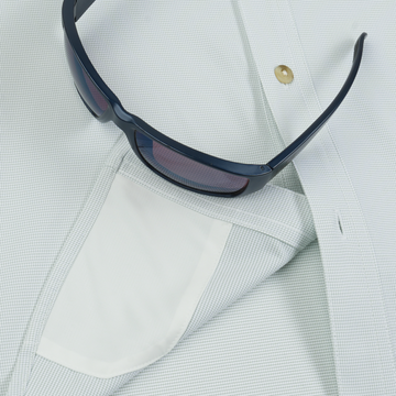 Close-up of a light patterned shirt pocket holding dark sunglasses, showcasing The Carolina Rig design.