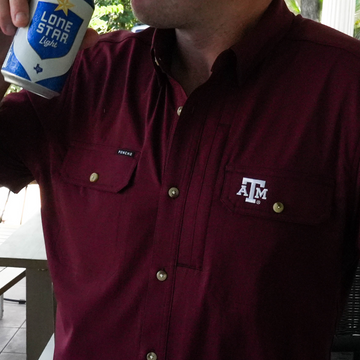 Man wearing maroon Texas A&M shirt holding a can of Lone Star Light beer