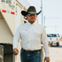 Man wearing cowboy hat and the crocket shirt next to trailer