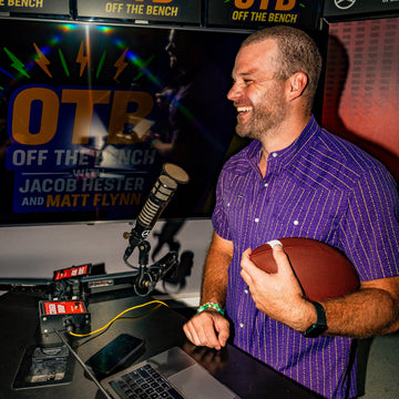 man with football and microphone wearing death valley shirt
