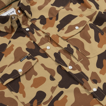 Close-up of The Delta Cowboy shirt featuring brown and beige camouflage pattern with snap button pockets and collar details.