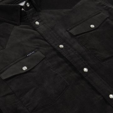Close-up of a black shirt with snap buttons and flap pockets, showcasing details of The Dusty Burro shirt design.