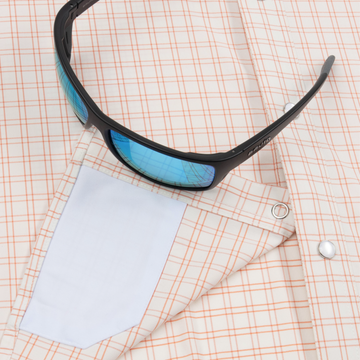 Closeup of sunglasses with lens cleaner on shirt