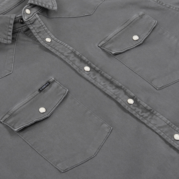 Close-up of The Falfurrias shirt in muted gray with snap buttons and front flap pockets.