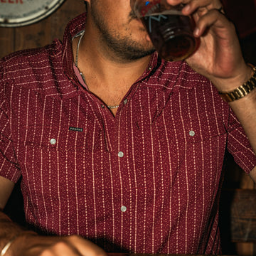 man with beverage wearing the farmer shirt