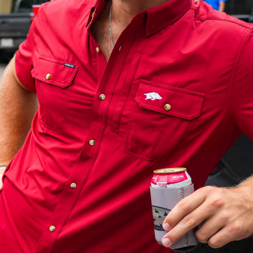 Close-up of a red button-up shirt named The Fayetteville with embroidered detail on the chest pocket and brass snap buttons