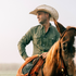 man riding horse wearing green long sleeve shirt