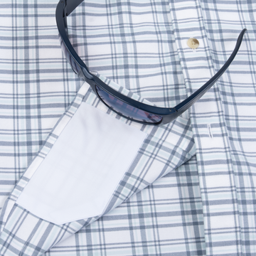 The Fog Horn shirt sleeve with blue plaid pattern and sunglasses resting on it