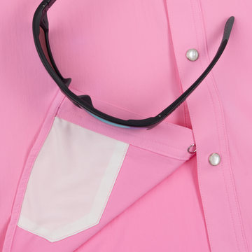 The Roughneck pink men's performance outdoor shirt close-up with pearl snaps, pocket, and sunglasses