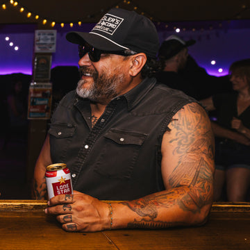 Man sitting at a bar wearing The Full Throttle Shirt