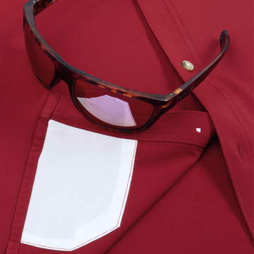 Close-up of burgundy shirt "The Gamecock" with contrasting white pocket and tortoiseshell sunglasses
