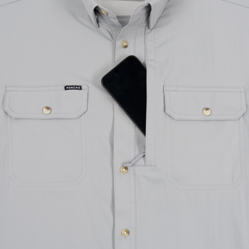 Close-up of a light grey shirt with buttoned chest pockets and a phone tucked into the hidden pocket, featuring The Grey Fox label.