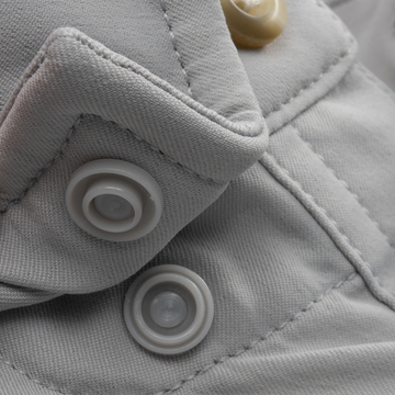 Close-up of button details and stitching on light gray fabric from The Grey Fox shirt.