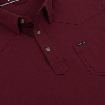 Close-up of burgundy button-up shirt pocket with Pomcho tag labeled The Gridiron