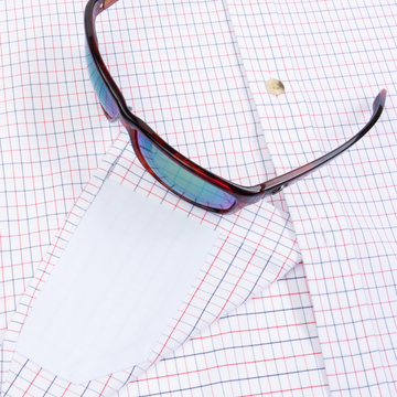 Closeup of sunglasses with lens cleaner on shirt
