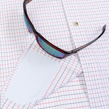 Closeup of sunglasses with lens cleaner on shirt