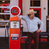 The Hammer Down shirt shown on a man in a cowboy hat beside a vintage gas pump