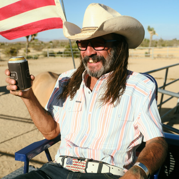 man with beverage sitting in chair