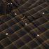 Close-up of The John Colter plaid button-up shirt in brown and black tones with snap closures and chest pockets