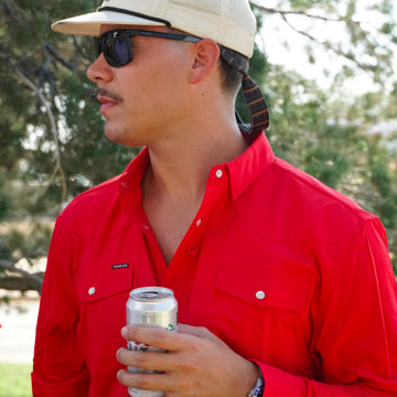 man holding beer wearing the jones shirt