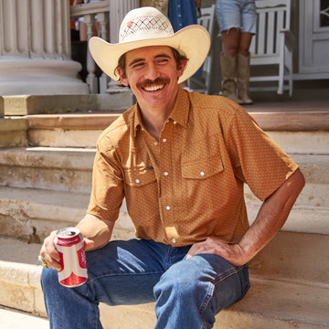 man holding beer wearing clyde short sleeve pearl snap shirt