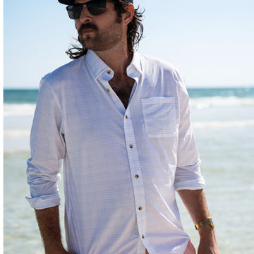 man wearing the live well shirt on beach