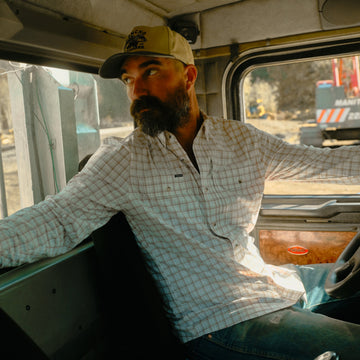 The Long Nose Pete maroon aqua white plaid men's outdoor shirt with long sleeves in a truck cab