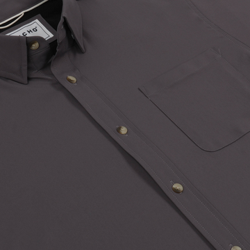 Close-up of a dark gray shirt with buttons and a chest pocket, showcasing The Lug Nut design.
