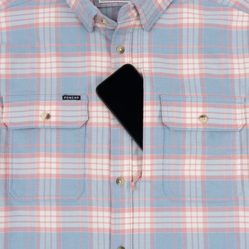 The Madaket shirt in pastel plaid with button-front and chest pockets, holding a phone in one pocket.
