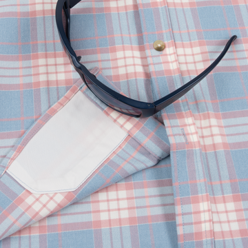 Close-up of The Madaket shirt in a pastel plaid pattern with blue sunglasses resting on the fabric pocket.