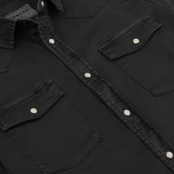 Close-up of The Matamoros shirt in black with pearl snap buttons and double chest pockets.