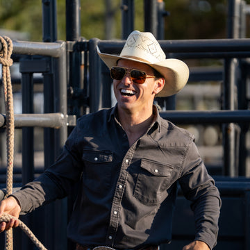 The Matamoros black button up shirt worn by a smiling man in a cowboy hat outdoors