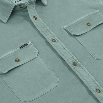 Close-up of light green button-up shirt with flap pockets and brown buttons from The Mentone collection by Poncho Outdoors