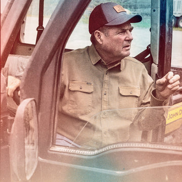 The Monteagle man wearing a tan button up shirt and cap inside a utility vehicle