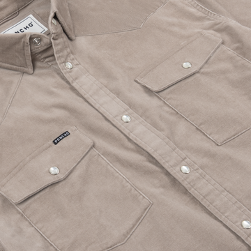 Close-up of The Mouflon shirt in beige with snap buttons and two chest pockets featuring flap closures.