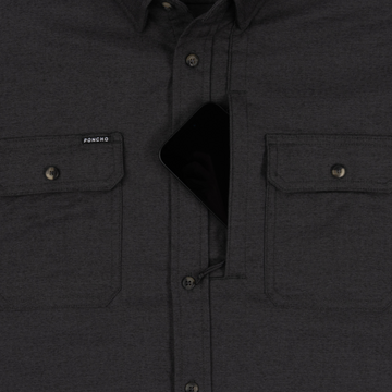 Close-up of The Nighthawk shirt in dark fabric featuring secure chest pockets, one holding a smartphone.