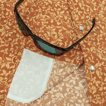 Close-up of a patterned shirt pocket with sunglasses resting on the fabric, featuring The Occupy Left Field design.