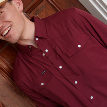 The Over the Shoulder burgundy button up shirt with chest pockets worn by a smiling man