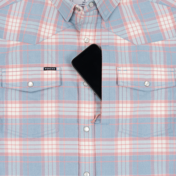 Close-up of The Pacific City shirt in pastel plaid with snap buttons and a smartphone tucked in the chest pocket