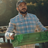The Pacific City red and blue plaid men's outdoor shirt worn outdoors while carrying a green crate