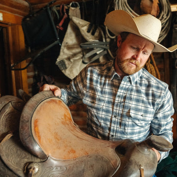 man with a saddle wearing the pagosa shirt