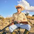 man sitting with shotgun wearing south texas camo