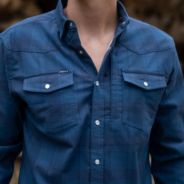 close-up of a blue button-up shirt with chest pockets from The Powder River collection