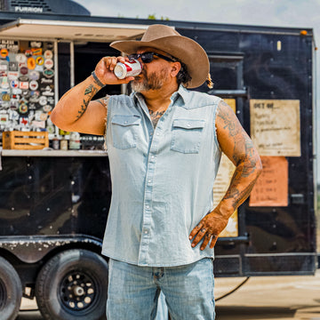 Man taking a drink wearing a Short Sleeve Denim Cutoff shirt
