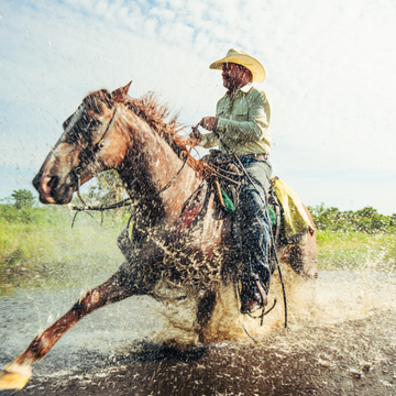 man riding horse wearing tan long sleeve tuff-thread shirt