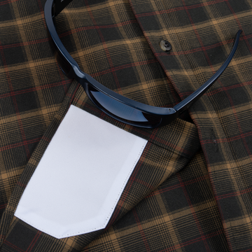 The Rusty Saw plaid shirt pocket with black sunglasses resting on top