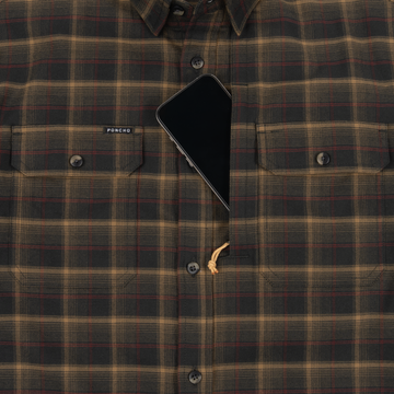 Close-up of The Rusty Saw plaid shirt with buttoned chest pockets and a smartphone partially tucked into one pocket